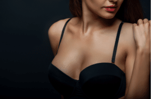 Close up of breast of attractive woman presenting her black bra. 1