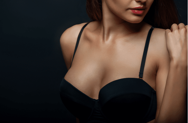 Close up of breast of attractive woman presenting her black bra. 1