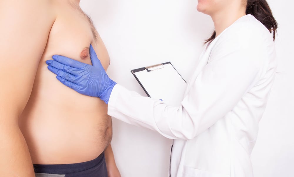 Plastic surgeon doctor examines the male breast before surgery. Male gynecomastia concept, liposuction