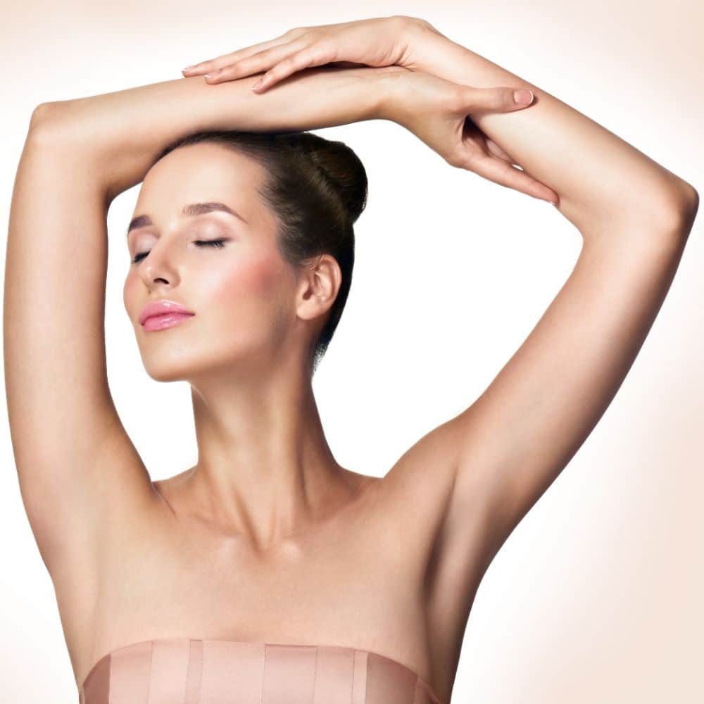 Beautiful young woman holding her arms up and showing clean underarms